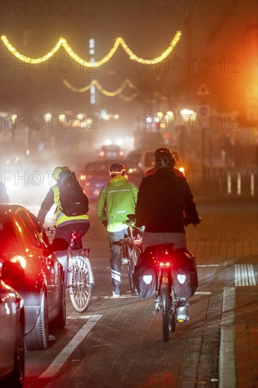 Cyclist, darkness, inner city traffic, Rüttenscheider Straße, bicycle lane, fog, autumn, winter, evening traffic, North Rhine-Westphalia, Germany, Europe
