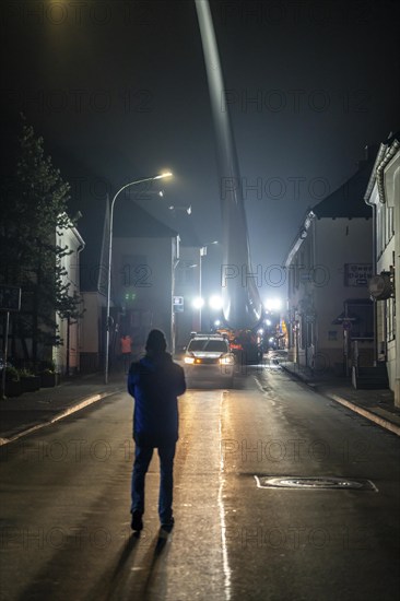 Transport of a 68 metre long, 22 tonne blade of a wind turbine, here in Breckerfeld, with a self-propelled Blade-Lifter vehicle, over a 40 km long route, over 2 nights, in the Bergisches Land, through towns, villages, over country roads, narrow through roads, to the construction site of the wind turbine near Hagen, North Rhine-Westphalia, Germany, Europe