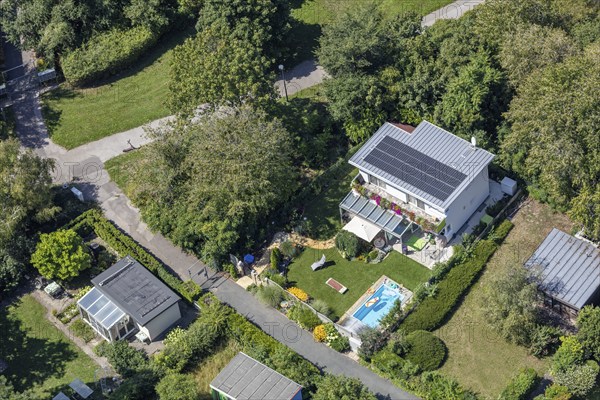 Aerial view of a modern house with garden, pool and solar panels on the roof, Vienna