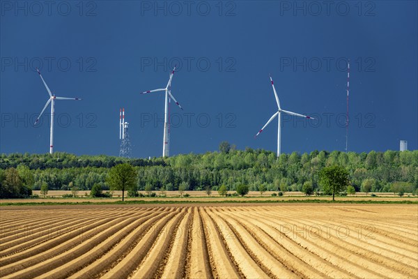 Wind turbines on the Grevenbroich wind test field, dark rain clouds, in the Rhenish lignite mining area, field with potato ridges, near Grevenbroich, North Rhine-Westphalia, Germany, Europe