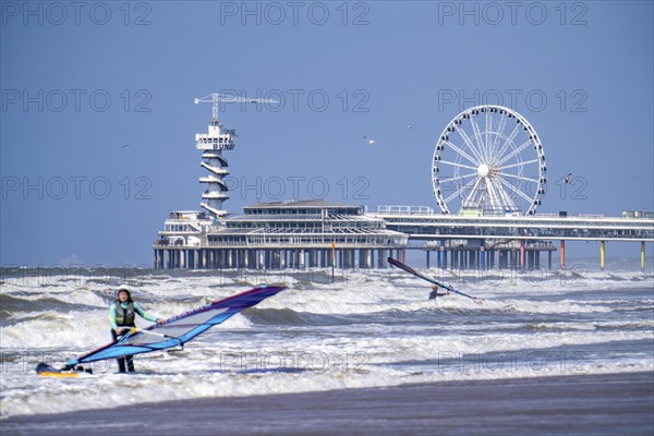 The pier and Ferris wheel at Scheveningen beach, strong swell, windsurfers, Netherlands