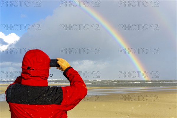 North Sea, Spiekeroog Island, autumn, rainy weather, with sun, rainbow, East Frisian Islands, beach walker take a photoLower Saxony, Germany, Europe