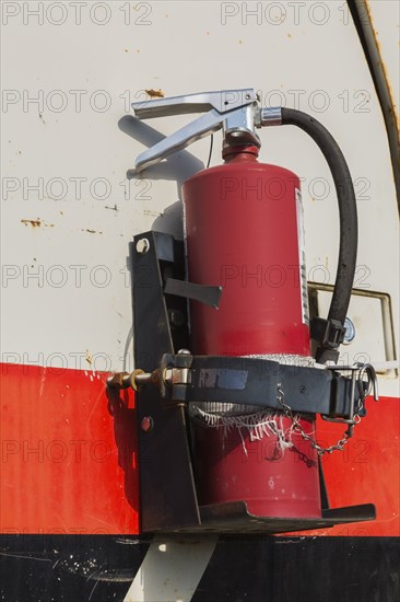 Close-up of fire extinguisher mounted on side of backhoe excavator, Quebec, Canada, North America