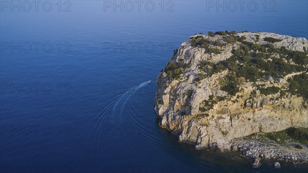 Drone shot, boat sailing along a rocky cliff over the clear blue sea, Anthony Quinn Bay, Vagies Bay, Rhodes, Dodecanese, Greek Islands, Greece, Europe