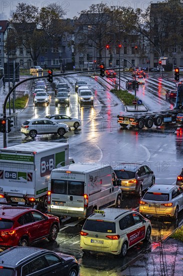 Rainy weather, road traffic, intersection, lights of vehicles on a wet road, traffic lights, tail lights, headlights, symbolic image