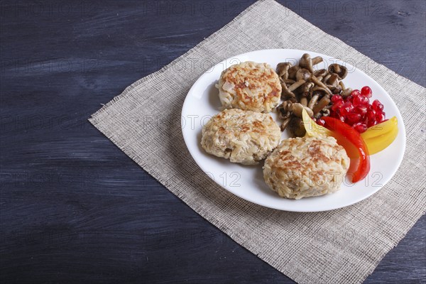 Meatballs with rice mushrooms, sweet peppers and pomegranate seeds on black wooden background. close up, copy space