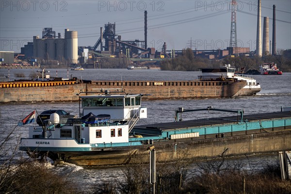 The Rhine near Duisburg, cargo ships, backdrop of the ThyssenKrupp Steel steelworks in Duisburg Marxloh, blast furnace Schwelgern 1, North Rhine-Westphalia, Germany, Europe