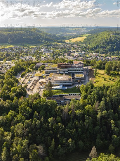 Aerial view of a town in green surroundings, many houses and a large building on a hill, blue summer sky, hospital, Nagold, Black Forest, Germany, Europe