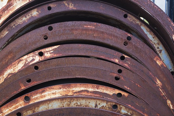 Close-up of rusted metal braces with drilled holes in junkyard, Quebec, Canada, North America