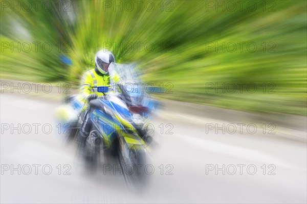 Policeman on a motorbike driving fast along the road, the speed is emphasised by the motion blur, Stuttgart, Baden-Württemberg, Germany, Europe