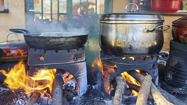 Several pots and pans cooking on open fires in a rustic kitchen, flames flickering on the logs, Drakona, Slowfood, Restaurant Dounias, Lefka Ori, White Mountains, mountain massif, west, Crete, Greece, Europe