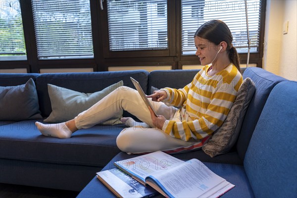 Homeschooling, girl, 11 years old, learns at home, home learning, lessons at home, distance learning, chat with teachers and classmates via tablet PC, symbolic image