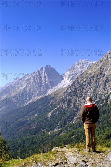 Hikers at the Staller Sattel, with Lake Antholz, behind Hochgall, between the Antholz Valley, South Tyrol Italy and the Defereggen Valley, East Tyrol, Austria, Europe