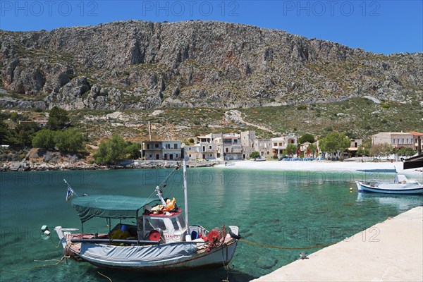Fishing boat in a quiet harbour in front of a steep mountain landscape in sunny weather, Geromilenas, Mani, Laconia, Peloponnese, Greece, Europe