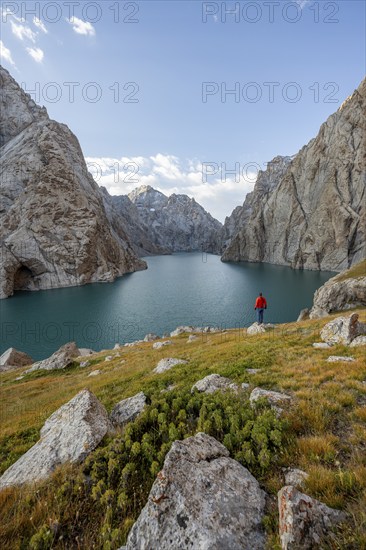 Tourist at the blue mountain lake between rocky steep mountain peaks, Kol Suu Lake, Sary Beles Mountains, Naryn Province, Kyrgyzstan, Asia