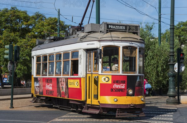 Yellow and red tram with advertising runs on rails in daylight, tram, Carros eléctricos de Lisboa, Eléctricos de Lisboa, Lisbon, Portugal, Europe