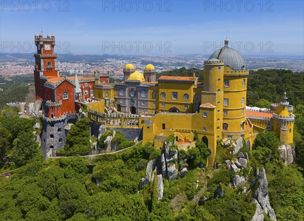 Magnificent castle with colourful towers and buildings in a green, hilly landscape under a blue sky, aerial view, Palácio Nacional da Pena, National Palace Pena, Sintra, Lisbon, World Heritage Site, UNESCO, Portugal, Europe