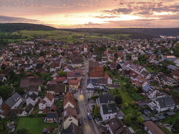Bird's eye view of village, sunset, many houses and roofs, central street, church, surrounded by green hills and fields, Calw, Black Forest, Germany, Europe