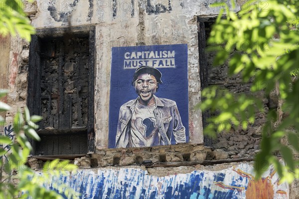 Poster critical of capitalism with a portrait of a coloured man in Exarchia, district of the students and alternative scene, Athens, Greece, Europe
