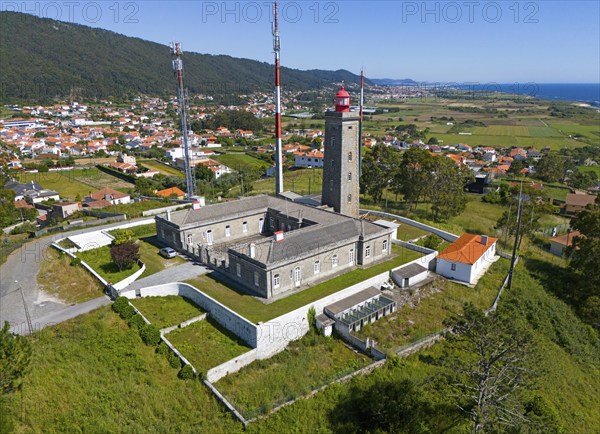 Lighthouse and other buildings in a hilly landscape with a village and the sea in the background, aerial view, Montedor, Viana do Castelo, Portugal, Europe