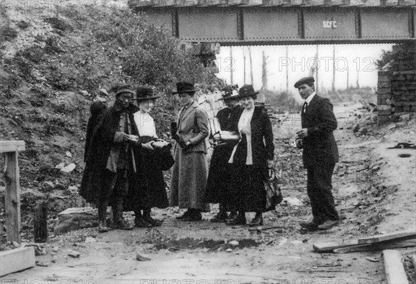 Belgian WWI battlefield tourists buying souvenirs from labourer of Chinese Labour Corps, CLC during World War One near Ypres, West Flanders, Belgium, Europe