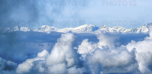 Snow-covered mountain range under a sea of clouds and blue sky, Val Gardena, South Tyrol, Italy, Europe