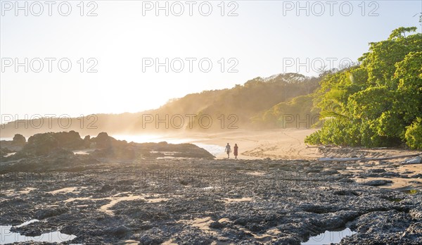 Two people on a sandy beach at sunset, Playa Cocalito, coastal landscape, Pacific coast, Nicoya Peninsula, Puntarenas Province, Costa Rica, Central America