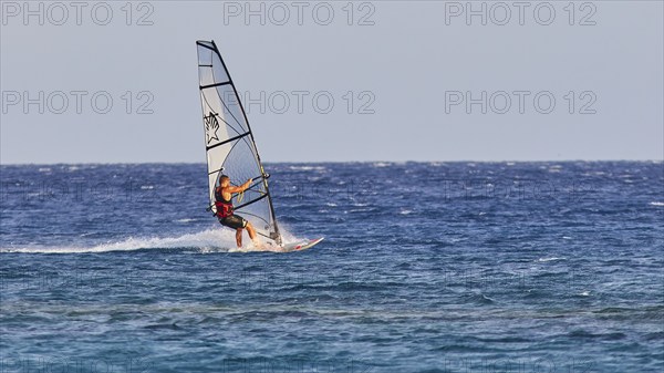A windsurfer with a stylish sail glides over the sea surface, windsurfer, Meltemi windsurfing spot, Devils Bay, Paralia Vatha, Vatha Beach, south-east coast, Karpathos, Dodecanese, Greek Islands, Greece, Europe