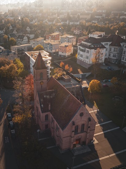 Church in urban surroundings in autumn weather and oblique sunlight, Nagold, Black Forest, Germany, Europe