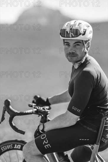 Road bike rider in spring near Halblech in the Allgäu in front of a picturesque backdrop of the Alps, Bavaria, Germany, Europe