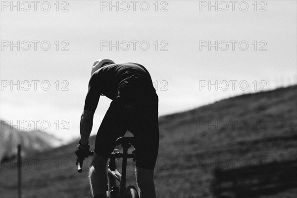 Road bike rider in spring in the Allgäu against the picturesque backdrop of the Alps, Bavaria, Germany, Europe
