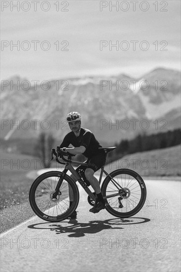 Road bike rider in spring in the Allgäu against the picturesque backdrop of the Alps, Bavaria, Germany, Europe