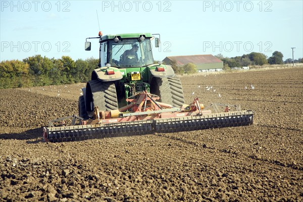 Tractor harrowing field, Parham, Suffolk, England, United Kingdom, Europe