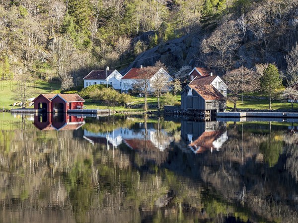 Fjord near Ana Sira at the norwegian southern coast, lonely houses at the of a rock formation, Norway, Europe
