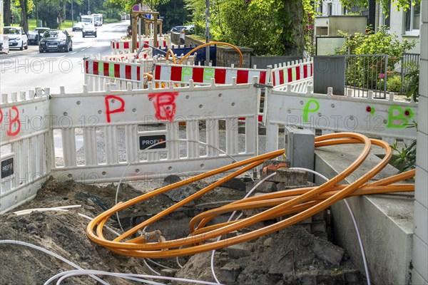 Laying of fibre optic cables, empty conduits are laid under a pavement, in which the actual fibre optic cable is later blown in and connected to the respective house connection or distributor. Essen, North Rhine-Westphalia, Germany, Europe