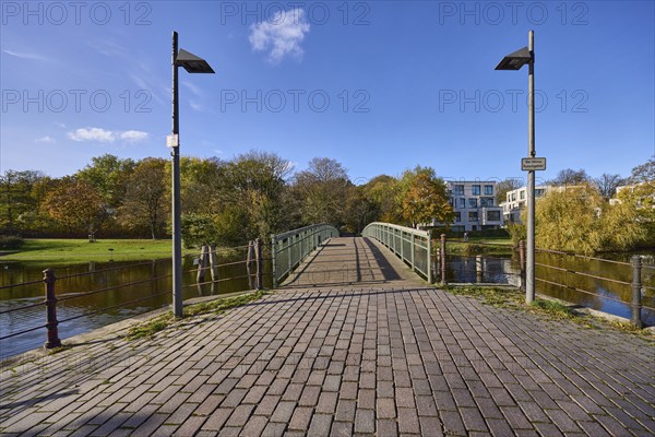 Pedestrian bridge Dankwartsbrücke, lanterns, trees, blue sky with fair weather clouds, river Trave, Hanseatic city of Lübeck, independent city, Schleswig-Holstein, Germany, Europe