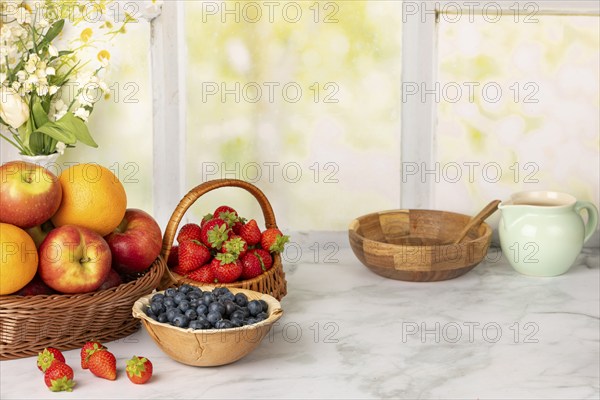 Healthy breakfast ingredients, fruit, strawberries and blueberries, ready for a meal in a wooden bowl