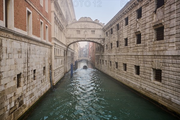 View from 'Ponte della paglia' on the bridge 'Bridge of Sighs' over a waterway before sunrise in Venice on a foggy morning in winter, Italy, Europe