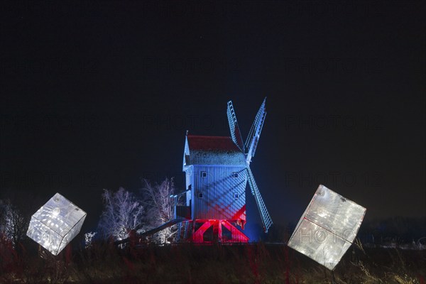 An illuminated windmill with abstract cubes in the foreground at night, world of lights, illumination, mill museum, Gifhorn, Lower Saxony, Germany, Europe