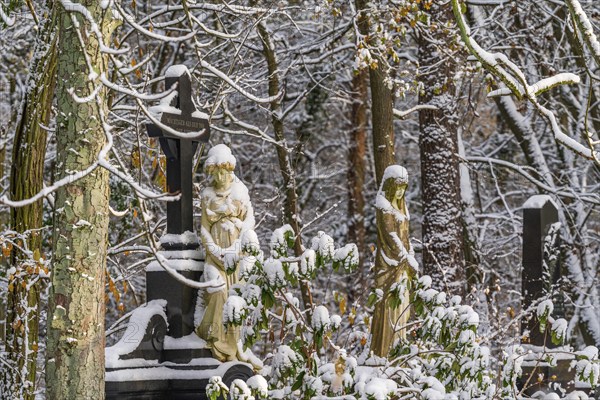Graves with stone sculptures of mourning woman in the snow, Südwest-Kirchhof, historic cemetery in Stahnsdorf, Potsdam-Mittelmark, Brandenburg, Germany, Europe
