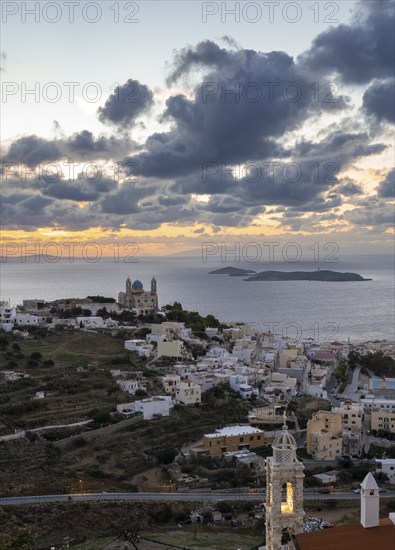 View from Ano Syros to the houses of Ermoupoli with the Anastasi Church or Church of the Resurrection, town view with islands and sea, dramatic cloudy sky at sunrise, Ano Syros, Syros, Cyclades, Greecev