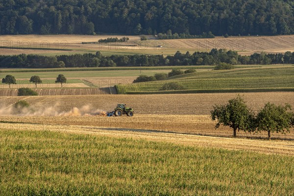 Tractor with plough digging up dried out soil, dust cloud, dust, dry, corn field, field, soil, ploughing, digging up, cultivated landscape, Ronneburger Hügelland, Glauberg, Glauburg, Wetterau, Hesse, Germany, Europe