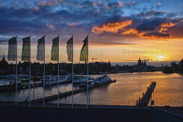 AMSTERDAM, NETHERLANDS, MAY 9, 2018: Amsterdam cityscape skyline with Church of Saint Nicholas (Sint-Nicolaaskerk) on sunset with dramatic sky from Nemo Science Museum. Amsterdam, Netherlands