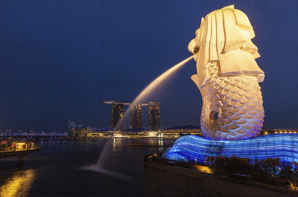 SINGAPORE, JANUARY 1, 2014: Night view of Singapore Merlion at Marina Bay and Marina Bay Sand complex. Merlion is a well-known tourist icon, mascot and national personification of Singapore