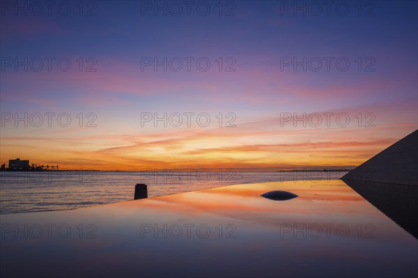Fountain and pool near the Champalimaud foundation, Portuguese non-profit foundation for scientific medical research in Belem with sunset reflection