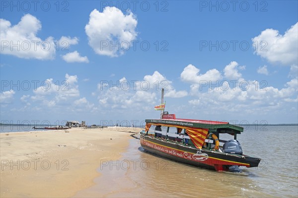 Wooden tourist boat, sightseeing boat beached on Braamspunt, sandbar on the Suriname River, where it meets the Atlantic Ocean, Commewijne, Suriname, South America