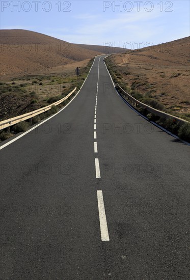 Tarmac road crossing barren desert mountainous land between Pajara and La Pared, Fuerteventura, Canary Islands, Spain, Europe