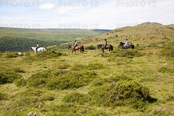 People riding horses by Sharp Tor, Dartmoor national park, Devon, England, UK