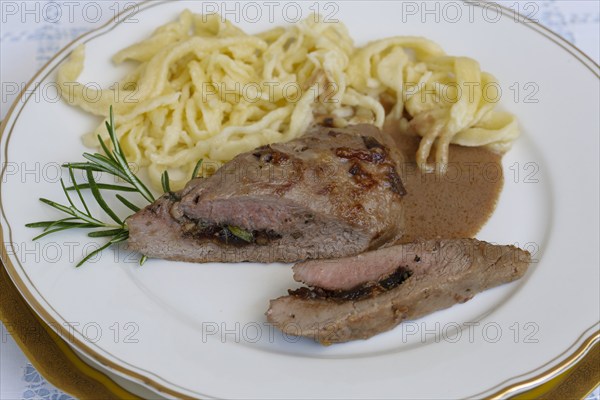 Swabian cuisine, lamb stuffed with prunes, rosemary, herbs, fillets arranged on plates, hand-scraped spaetzle, gravy, grandmother's cooking, regional, home cooking, typical Swabian, traditional cuisine reinterpreted, food photography, studio, Germany, Europe