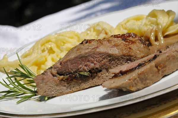 Swabian cuisine, lamb stuffed with prunes, rosemary, herbs, fillets arranged on plates, hand-scraped spaetzle, gravy, grandmother's cooking, regional, home cooking, typical Swabian, traditional cuisine reinterpreted, food photography, studio, Germany, Europe